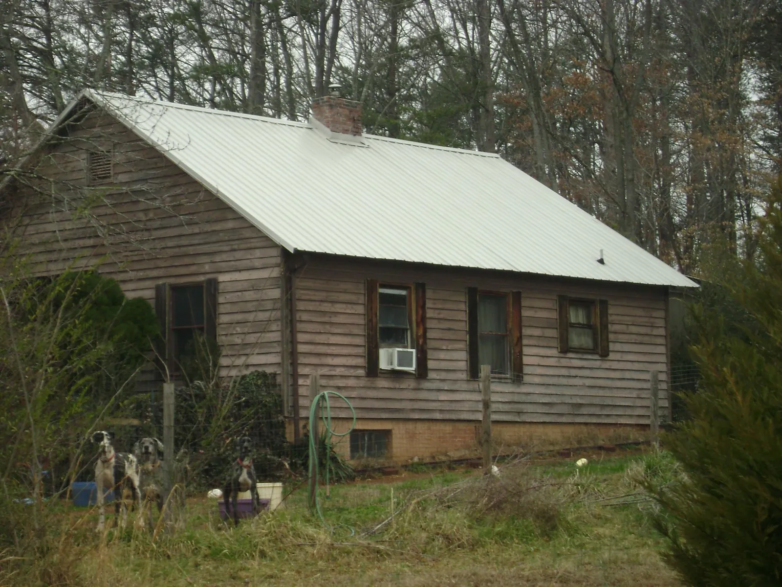 White metal roof on an old wood sided farmhouse, from a Metal Roof Installation job in Mc Bee